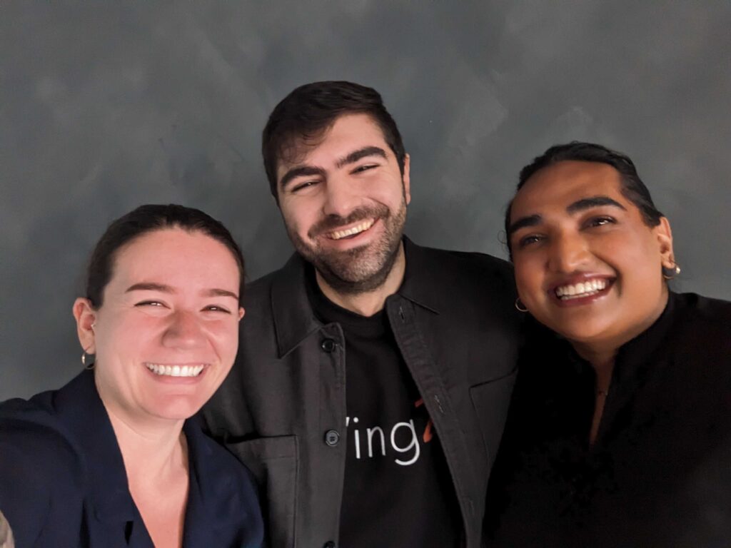 Three people, including Hossein Rezaei (centre), pose together for a smiling selfie